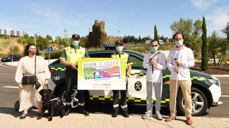 Dos agentes de la Guardia Civil y tres afiliados a la ONCE posan con la imagen de uno de los cupones. Foto: ONCE